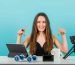smiling-young-girl-is-showing-her-camera-tablet-with-forefingers-blue-background-min